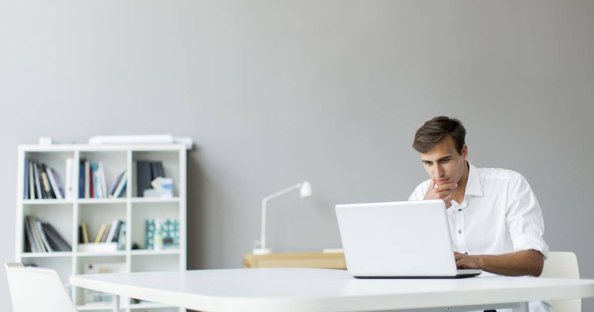 Man werkt thuis met laptop aan tafel